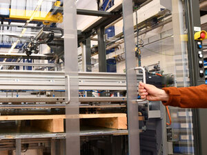 Macchinario industriale con un braccio meccanico in un ambiente di produzione